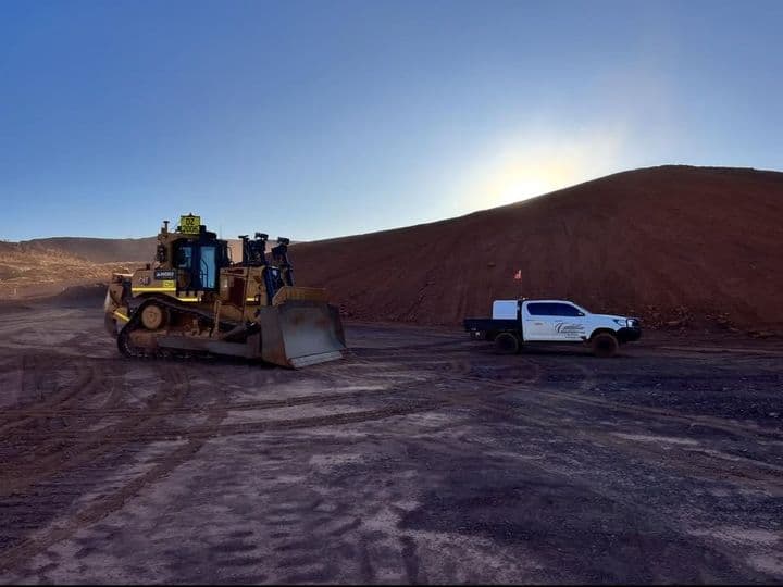 Dozer and site ute on a formed haul road at last light
