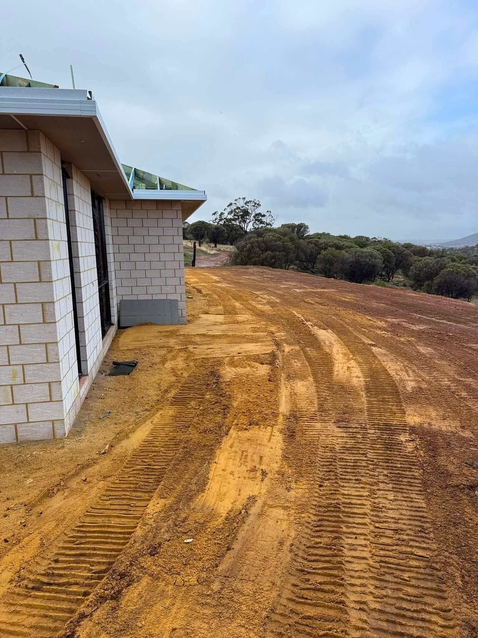 House pad cut and track-rolled beside a brick home